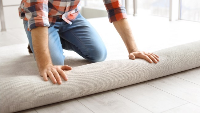 Man rolling carpet for installation | CarpetsPlus COLORTILE