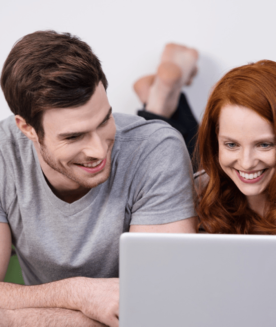 Happy couple with laptop | CarpetsPlus COLORTILE